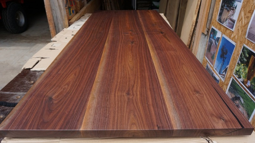 Finished walnut tabletop on workbench